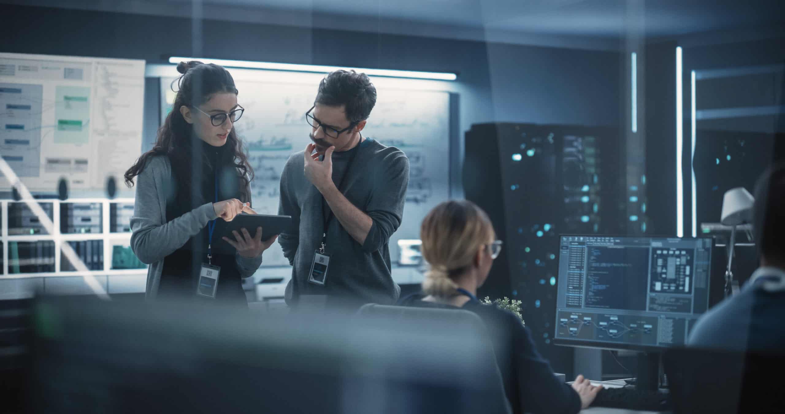 Portrait of Two Creative Young Female and Male Engineers Using Technology